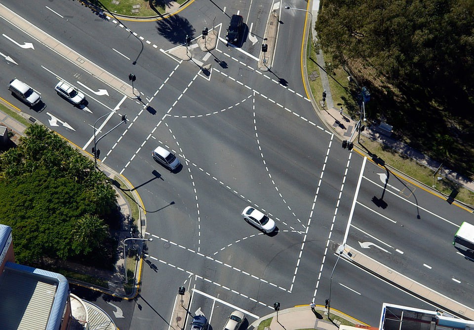 Foto de una intersección con semaforos en una avenida de dos carriles ambas direcciónes